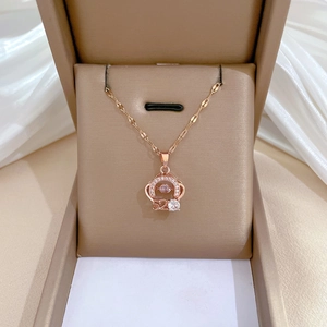 Macro view of rose gold crown necklace with 520 pendant and crystals in a jewelry box