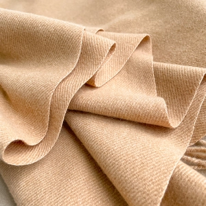Dettaglio macro del tessuto sciarpa in cashmere cammello con trama morbida e fibre di lana