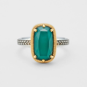 Detailansicht eines zweifarbigen Rings mit grünem Edelstein und gewebter Goldtextur