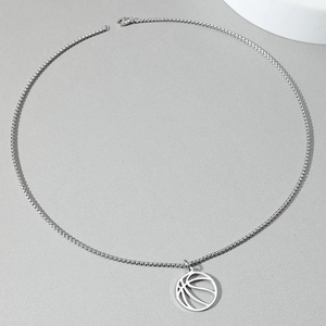 Detail van de holle basketbal hanger en zilveren box ketting op getextureerde grond