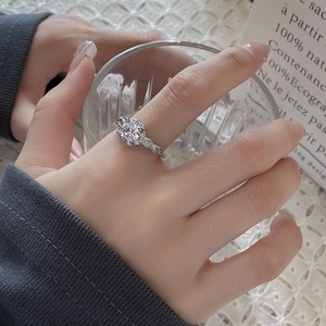 Elegant silver ring with a large round zircon and twisted band worn by a model