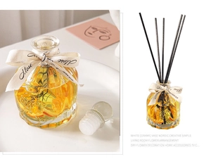 Detail view of faceted glass diffuser with citrus slices, botanical stems and reeds