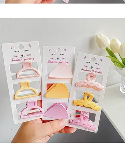 Detailed view of three matte pastel mini hair claws in pink, yellow and purple set