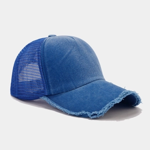 Dettaglio laterale di un cappello vintage blu lavato con mesh traspirante e visiera usurata