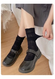 Detail of black hollow lace ankle socks paired with vintage matte Mary Jane shoes