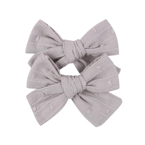 Detailed texture of gray cotton linen bow hair clip with white jacquard dots
