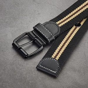 Unisex canvas belt with black buckle, featuring brown and beige stripes on a stone surface