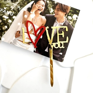 Dettaglio cake topper in acrilico specchio oro con cuore rosso e design LOVE you