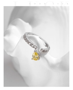 Detail of silver open ring featuring micro-pave diamonds and yellow pear-cut gemstone