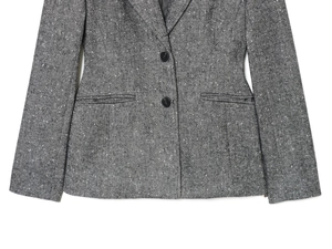 Detailed macro view of herringbone tweed texture and double-button closure on a grey blazer