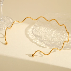 Elegant 18K gold-plated stainless steel wave-shaped necklace on minimalist background