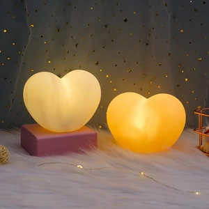 Macro detail of two heart-shaped decorative night lights glowing on soft white faux fur