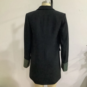 Detail eines schwarzen Blazers mit grünem Pailletten-Patchwork an den Manschetten und Slim-Fit