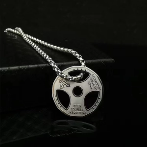 Vue détaillée du pendentif haltère en argent avec citation motivante sur fond noir