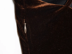Gros plan sur la texture du velours marron et la fermeture éclair invisible de la robe