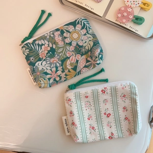 Floral print canvas coin purses with zipper and woven puller on minimalist background