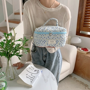 Trousse de toilette en coton matelassé à carreaux bleu et jaune dans un cadre cosy