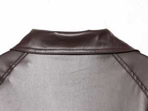 Close-up of the lapel collar and stitching details on a dark brown faux leather jacket