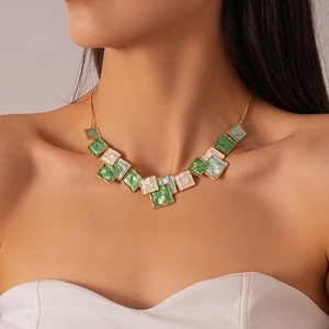 Detail of vintage geometric green oil-drop square necklace on model for a resort look