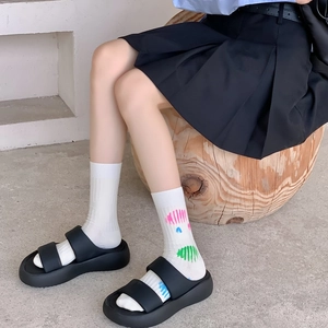 Women's black platform sandals with double straps paired with paint splatter cotton socks