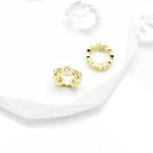 Gold-plated hollow coin ring with cubic zirconia on geometric white display base