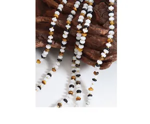 Close-up of handmade white jade and tiger eye beaded necklace with gold spacer beads