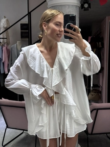 Détail de la blouse blanche à volants, manches bouffantes et short à cordon assorti