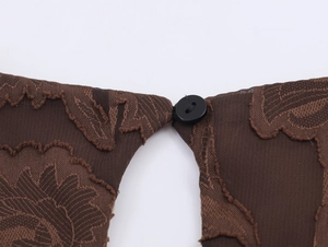 Détail de la texture en dentelle marron foncé et bouton noir rond sur la robe élégante