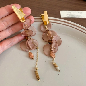 Close-up of chiffon flower tassel earrings with golden vintage finish and resin beads