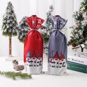 Christmas wine bottle covers with gnome prints and snowflake ribbons for table decor