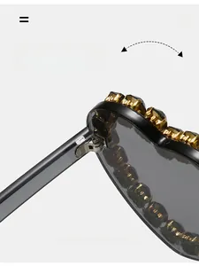 Detailed macro view of the durable gold-textured metal hinge on heart-shaped sunglasses