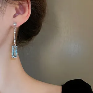 Silver needle geometric drop earrings featuring a blue rectangular zircon and tassels