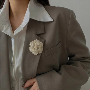 Élégante broche camélia crème avec perles sur revers de costume pour un style luxe rétro