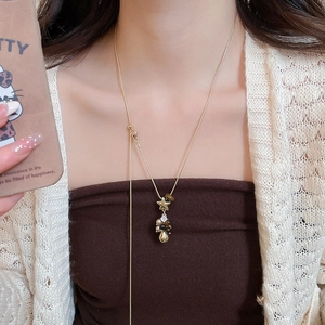 Détail d'un collier en Y doré orné d'une étoile, de perles œil de tigre et de perles