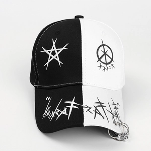 Detailed view of black and white baseball cap with metal rings and graffiti print