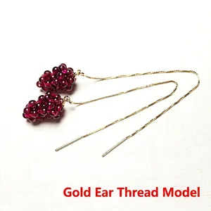 Detailed close-up of handmade wine red garnet grape cluster earrings with gold ear wires