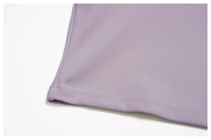 Détail du haut de yoga lavande montrant l'ourlet avec couture plate professionnelle précise