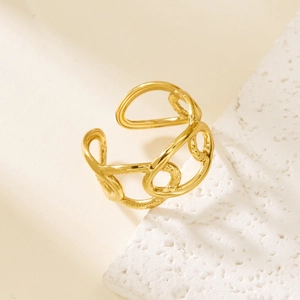 Close-up of golden irregular geometric cross ring on decorative stone background