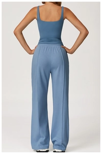 Vue arrière d'un débardeur de yoga bleu moulant avec un pantalon large de sport assorti