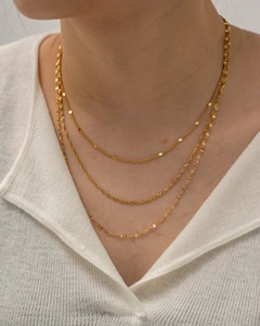 Close-up of triple layered 18k gold plated stainless steel necklaces on a model