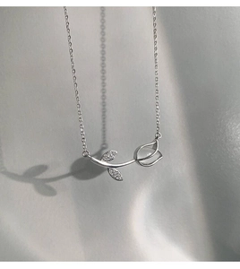 Macro detail of tulip pendant with white chalcedony and small diamonds on silver chain