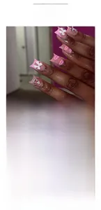 Détail de faux ongles imprimé lèvres roses avec nœuds 3D et accents de cristal
