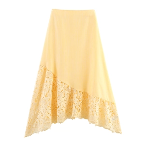 Detail of light yellow skirt featuring asymmetrical hem with intricate lace patchwork