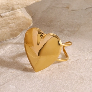 Polished 18k gold plated stainless steel heart locket ring on a stone surface