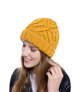 Detailed knit texture of ginger yellow diamond pattern beanie on a model