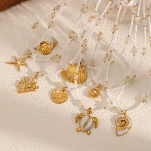 Marine themed necklace with gold sea turtle shell charms and white beaded stones