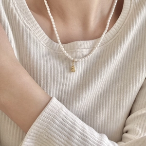 Elegant 925 sterling silver pearl necklace featuring a cute gold bear pendant on a model