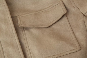 Detailed macro view of camel suede jacket featuring double-needle stitching and pocket