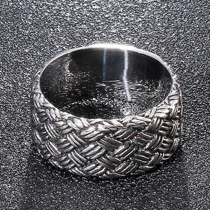 Macro d'une bague pour homme en acier inoxydable montrant la texture tressée détaillée