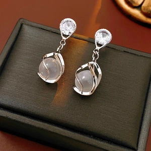 Macro shot of silver drop earrings with moonstone and cubic zirconia on a jewelry box